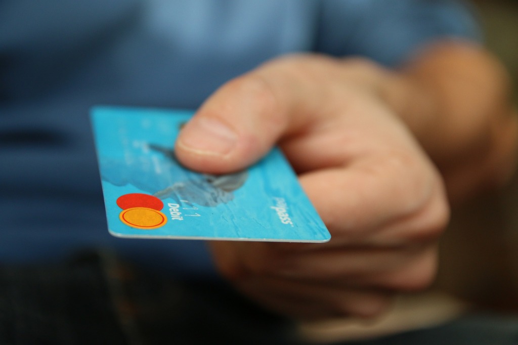 Image of a person handing over a bank card